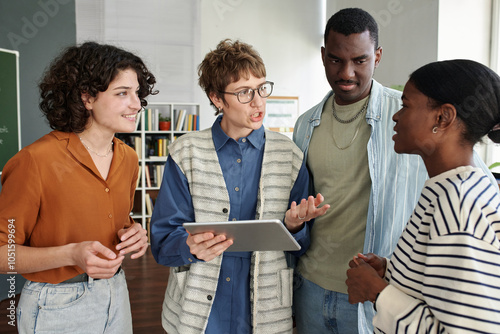 Foto Group of four people engaging in conversation while one holds a tablet