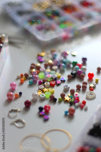Colorful beads, letter beads, threads and other jewelry making supplies on white background. Making friendship bracelets concept. Selective focus.