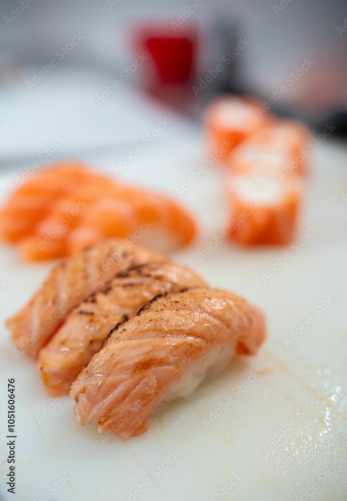 Fototapeta premium Fresh salmon sushi close-up on cutting board.