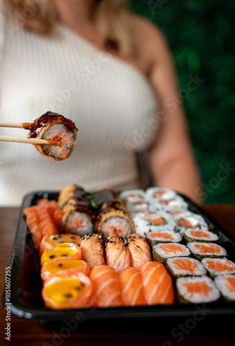 Assorted sushi rolls with chopsticks.