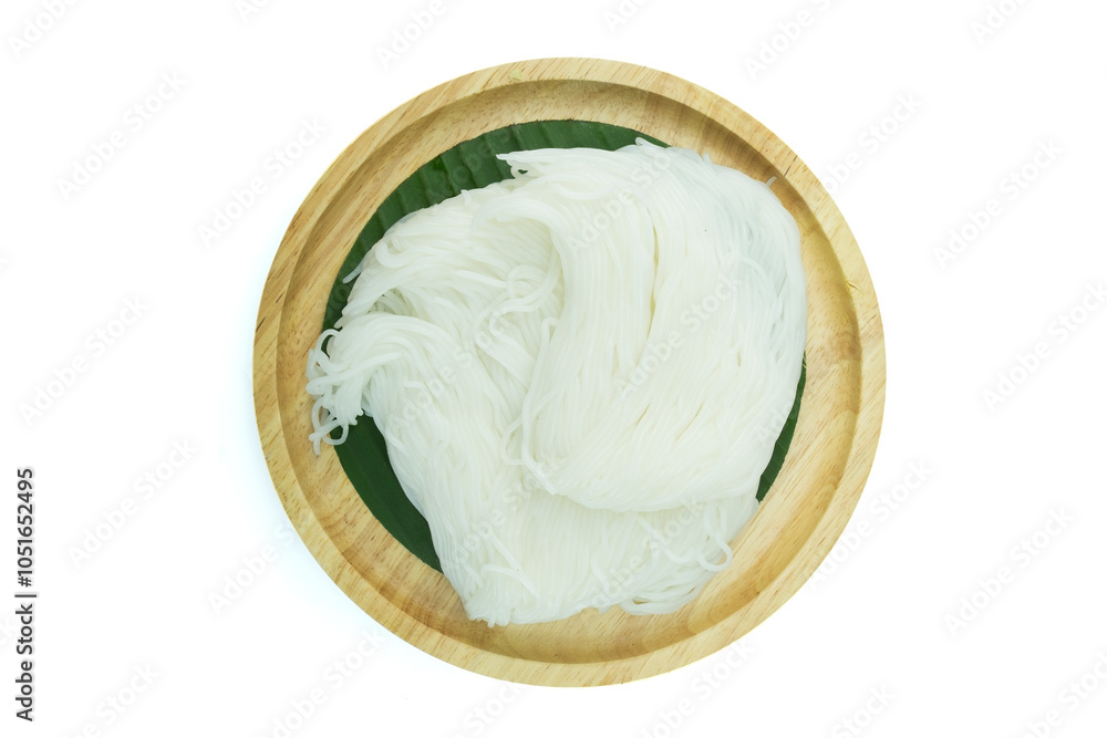 A wooden plate of Thai fermented rice flour noodles or rice vernicelli, Khanom Jeen in Thai, on green banana leaf isolated on white background top view flat lay with clipping path stcking A wooden plate of Thai fermented rice flour noodles or rice vernicelli, Khanom Jeen in Thai, on green banana leaf isolated on white background top view flat lay with clipping path stcking
