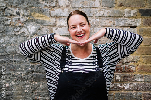 Happy mature woman posing in front of brick wall photo