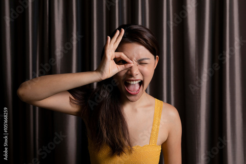 Cheerful woman pretending to wear glasses in photo booth photo