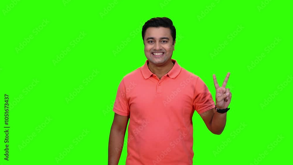 A Young Male model is happy and successful showing victory gestures. Chroma key,green screen. Success, Victory, Winner.