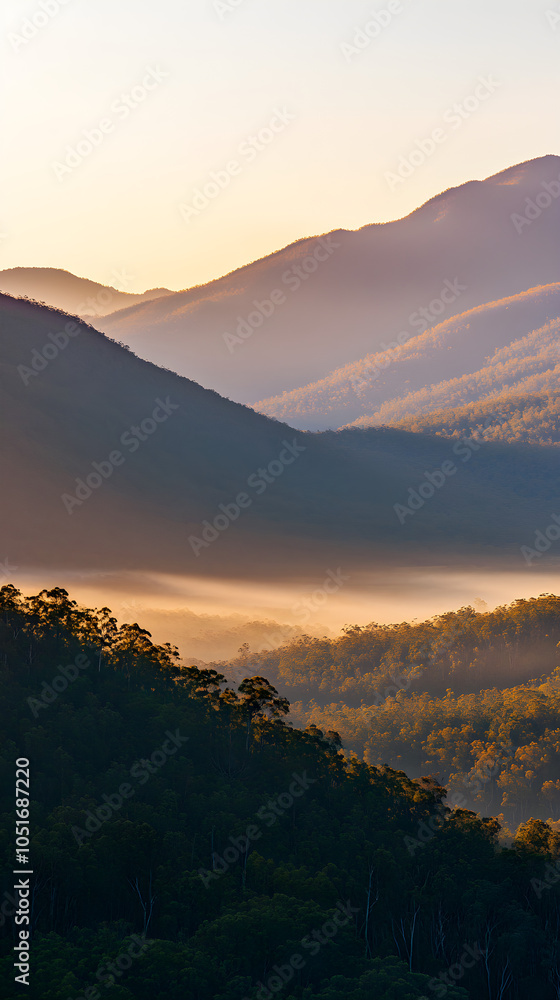 Obraz premium Majestic mountain range at sunrise with low-hanging mist gently rolling through the valleys