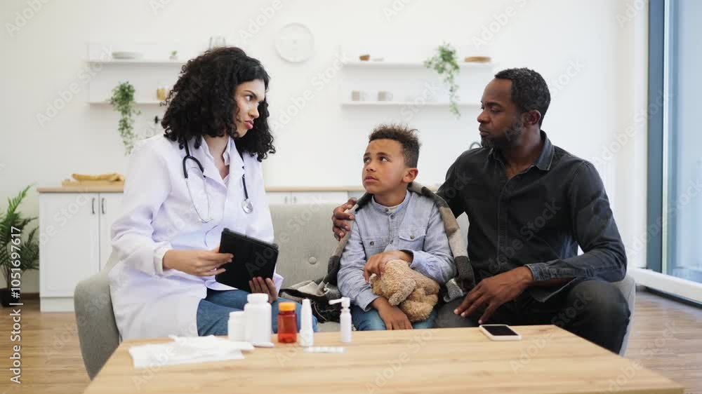 Female doctor discusses treatment with young boy holding teddy bear, accompanied by adult male. Scene captures caring medical environment, highlighting pediatric care and supportive family presence. Female doctor discusses treatment with young boy holding teddy bear, accompanied by adult male. Scene captures caring medical environment, highlighting pediatric care and supportive family presence.