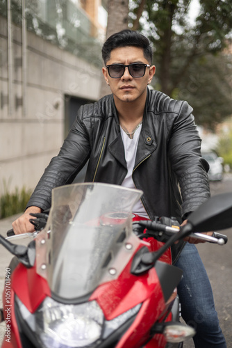 Wearing casual clothes and sunglasses, male model sitting on his motorcycle on a sunny day photo