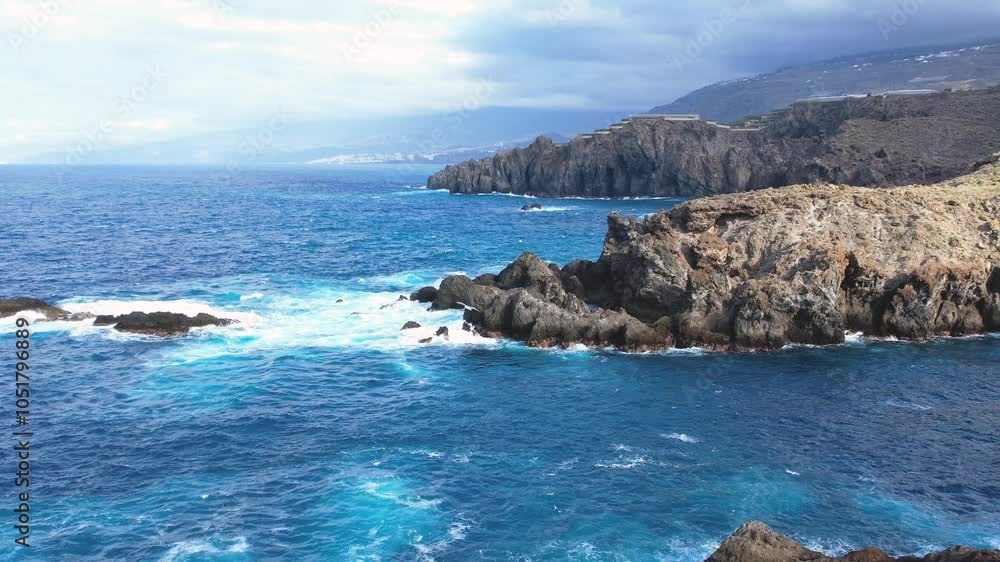 Aerial tracking view of ocean waves splash against lava rocks background, Tenerife island, Canary islands, Spain Aerial tracking view of ocean waves splash against lava rocks background, Tenerife island, Canary islands, Spain