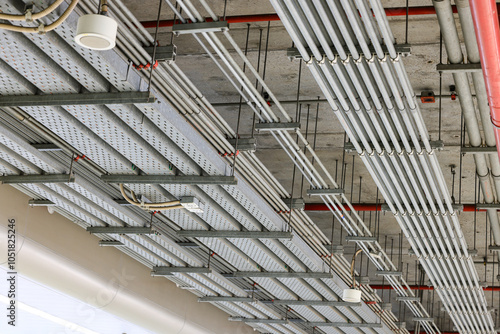 electrical steel pipeline, Electrical cable wire way on wall, cable routing between electrical distribution panel with equipment, industry construction concept background.