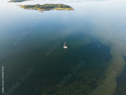 A sailing yacht is anchored off the coast of the Estonian island Krasuli on a summer day, photo view from a drone. photo