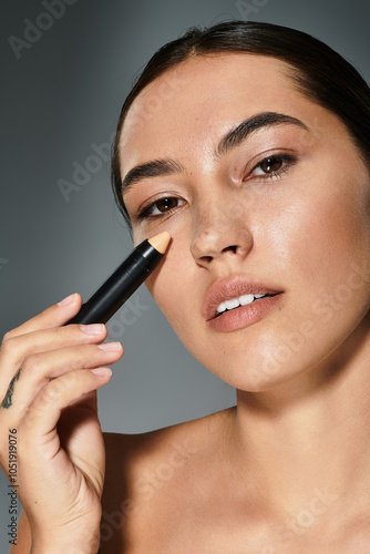The woman applies concealer to accentuate her features, showcasing a serene expression.