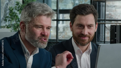 Close-up two joyful Caucasian men businessmen looking at computer screen discussing financial trading project at office meeting discuss presentation business partners conclude profitable deal contract