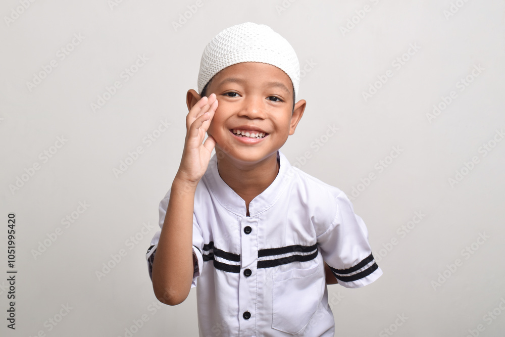 Asian Muslim boy doing whispering gesture isolated on white background Asian Muslim boy doing whispering gesture isolated on white background