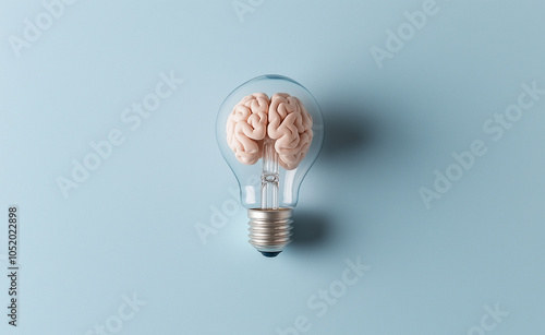 Brain Inside Lightbulb on Blue Background: A lightbulb with a brain inside against a blue background, symbolizing creativity and innovative ideas. photo