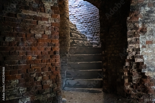 A narrow spiral brick staircase in the Bobruisk fortress. Sunlight inside