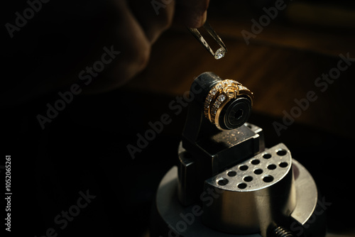 craftsman making diamond ring. hand made jewelry. Put diamond gem ring. diamond ring production. hand made in craftsman workshop close up. black background.