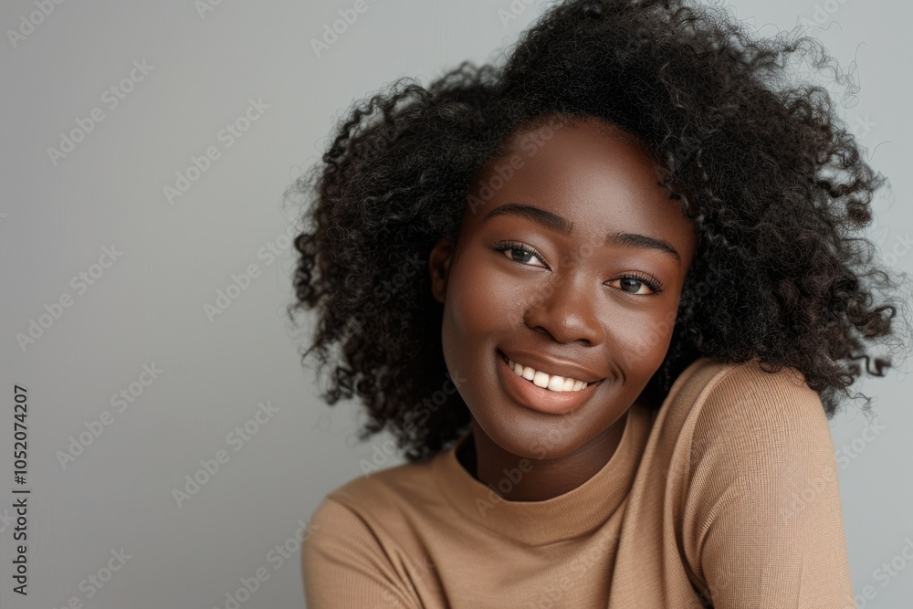 Smiling African woman with curly hair on grey background. Smiling African woman with curly hair on grey background.