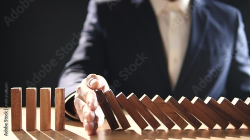 Concept Recession, Risk Assessment, Risk, Management, Business, Inflation, Economic, Financial Crisis. Business man stop wooden block domino effect to safe, protect family, home from economic crisis.
