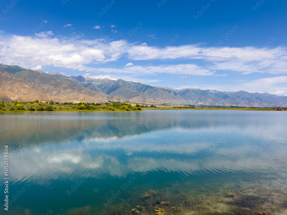 Obraz premium A wooden staircase leading into the clear waters of Issyk-Kul lake, with visible underwater vegetation. A perfect spot for water relaxation and enjoying nature