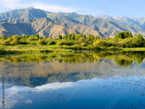 A quiet mountain lake Issyk-Kul, surrounded by green valleys and majestic mountains. The perfect spot for tourism and peaceful relaxation in Kyrgyzstan.