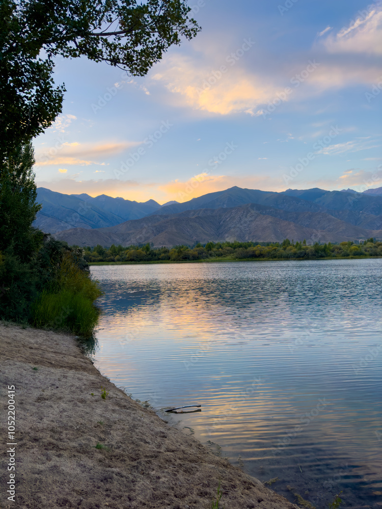 A quiet mountain lake Issyk-Kul, surrounded by green valleys and majestic mountains. The perfect spot for tourism and peaceful relaxation in Kyrgyzstan. A quiet mountain lake Issyk-Kul, surrounded by green valleys and majestic mountains. The perfect spot for tourism and peaceful relaxation in Kyrgyzstan.