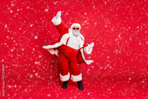 Full length size photo of carefree delightful rejoicing funky holly-jolly moving st nicholas father christmas big belly in suspenders traditional outfit fur trousers sunglass boots isolated background