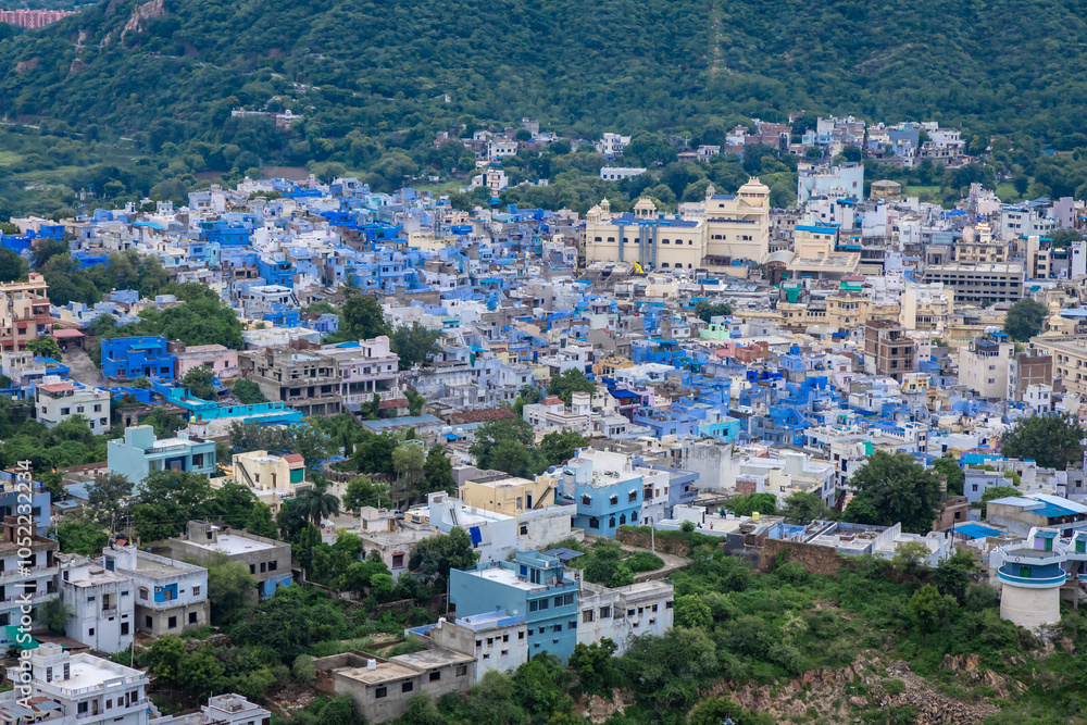 Fototapeta premium Aerial View of Crowded Blue City Houses at Mountain Base in the Evening