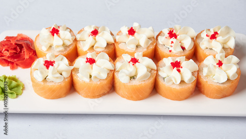 Gourmet salmon sushi rolls served on a black plate with garnishes, ready for a fine dining experience