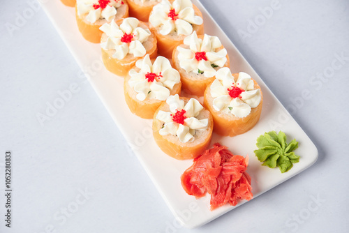 Gourmet salmon sushi rolls served on a black plate with garnishes, ready for a fine dining experience