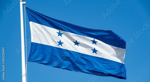 Honduras national flag with stars on blue and white stripes against clear sky. photo