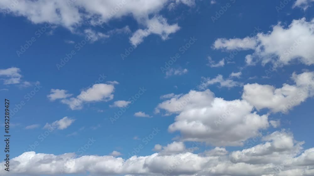 White cumulus clouds moving across the beautiful sky at midday White cumulus clouds moving across the beautiful sky at midday