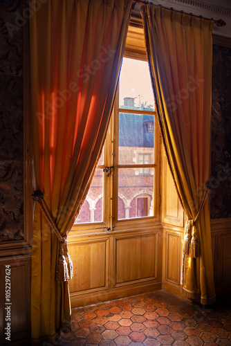 Evening or morning sun entering an old-style room through red curtains photo