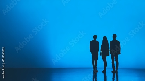 Silhouettes of Three People Standing Against a Blue Background photo