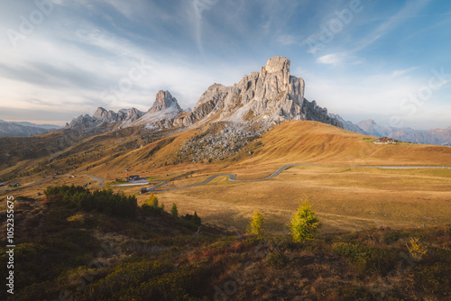 Idyllic alpine landscape of the Italian Dolomites at Giau Pass, with the rugged Ra Gusela peak bathed in golden light, set against a dramatic sky and autumnal highlands in Belluno, Italy. photo