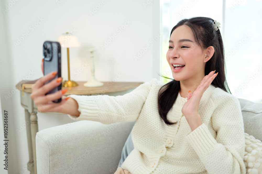 Young Asian woman enjoy using smartphone in living room at home Young Asian woman enjoy using smartphone in living room at home