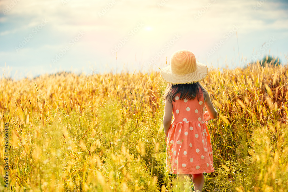 Φωτογραφία Happy little girl in a straw hat walking in the wheat field on a sunny summer da