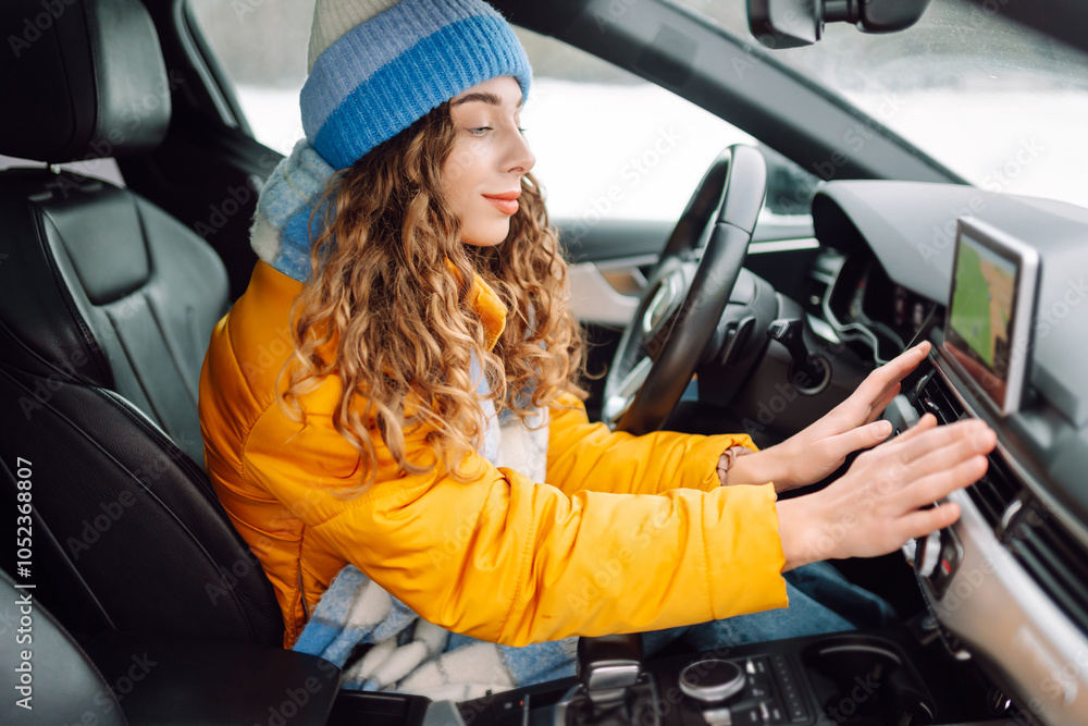 Young woman holds her hands over the car's hot air outlet. Cold hands. Travelling in winter. Young woman holds her hands over the car's hot air outlet. Cold hands. Travelling in winter.