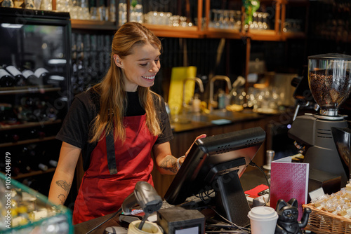 A cheerful barista skillfully using a modern pointofsale system in a bustling coffee shop environment photo