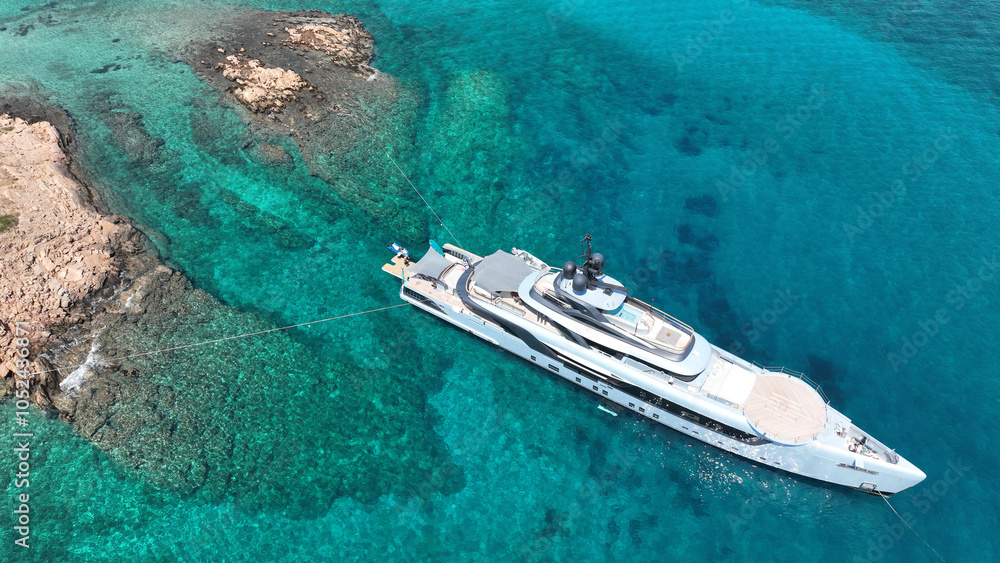 Aerial drone top down photo with copy space of luxury yacht anchored in tropical exotic island with crystal clear turquoise sea