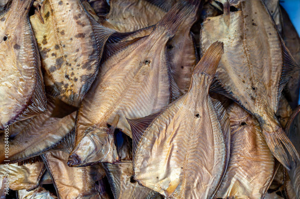 Dried fish arranged neatly for sale at a bustling market in an Asian coastal town during daytime Dried fish arranged neatly for sale at a bustling market in an Asian coastal town during daytime