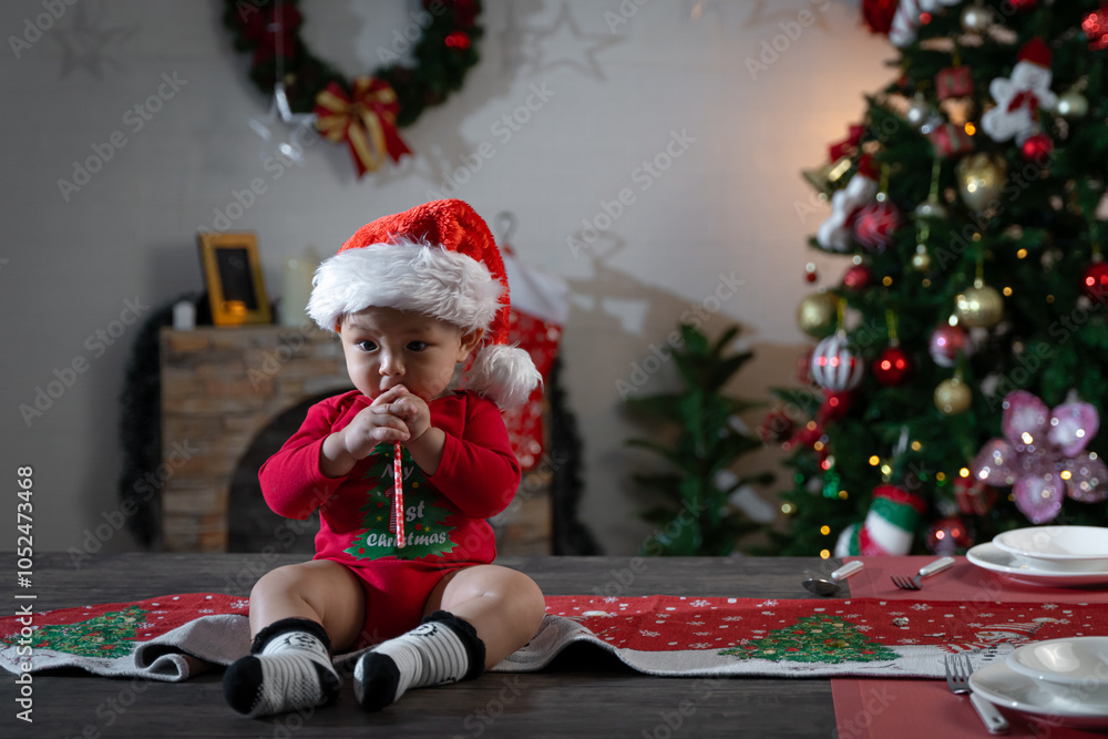 Asian baby sitting on a dining table on Christmas Day. Asian baby sitting on a dining table on Christmas Day.