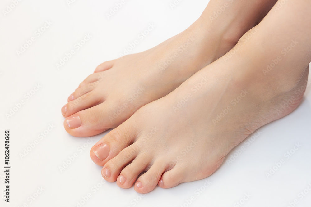 Close-up photo of well-groomed legs of a young woman with a beautiful nude pedicure after spa on a white background Close-up photo of well-groomed legs of a young woman with a beautiful nude pedicure after spa on a white background