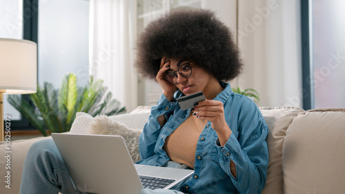 African American woman sad girl frustrated with insufficient funds problems payment online credit bank card trouble failure internet shopping bankruptcy use laptop try pay blocked scam fraud at home