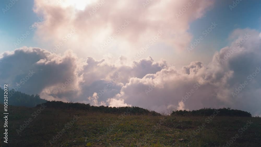 Time lapse flowing through clouds creates stunning sight in mountain meadow. Picturesque scene unfolds with bright grass and serene sky, embodying beauty of nature Time lapse flowing through clouds creates stunning sight in mountain meadow. Picturesque scene unfolds with bright grass and serene sky, embodying beauty of nature