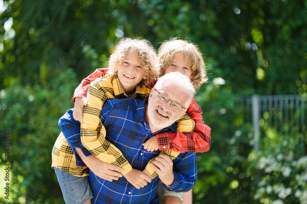 Fototapeta premium Grandfather and kids in sunny garden