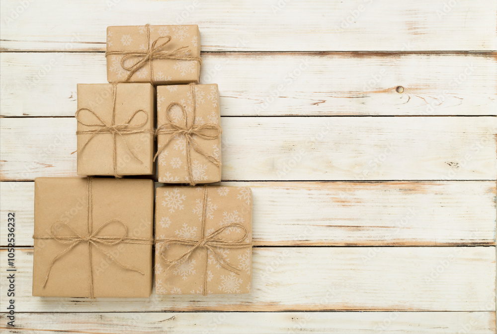 Fototapeta premium Gift boxes in Christmas tree shape on wooden background, top view