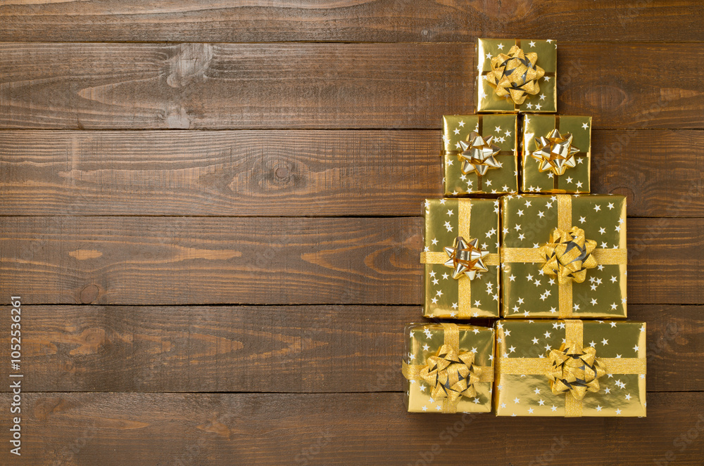 Obraz premium Gift boxes in Christmas tree shape on wooden background, top view
