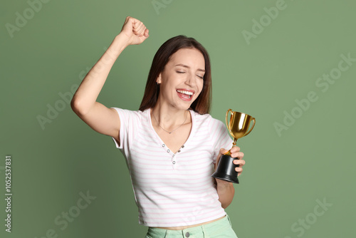 Happy winner with gold trophy cup on green background