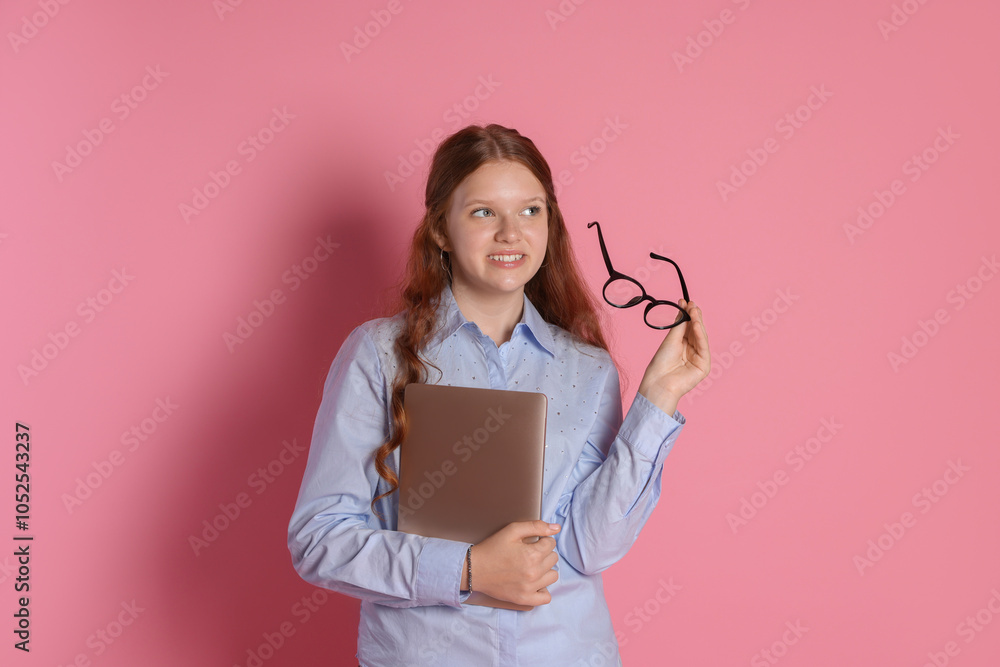Smiling teenage girl with laptop and glasses on pink background Smiling teenage girl with laptop and glasses on pink background