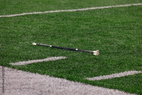 Close-up of a majorette baton lying on a football field